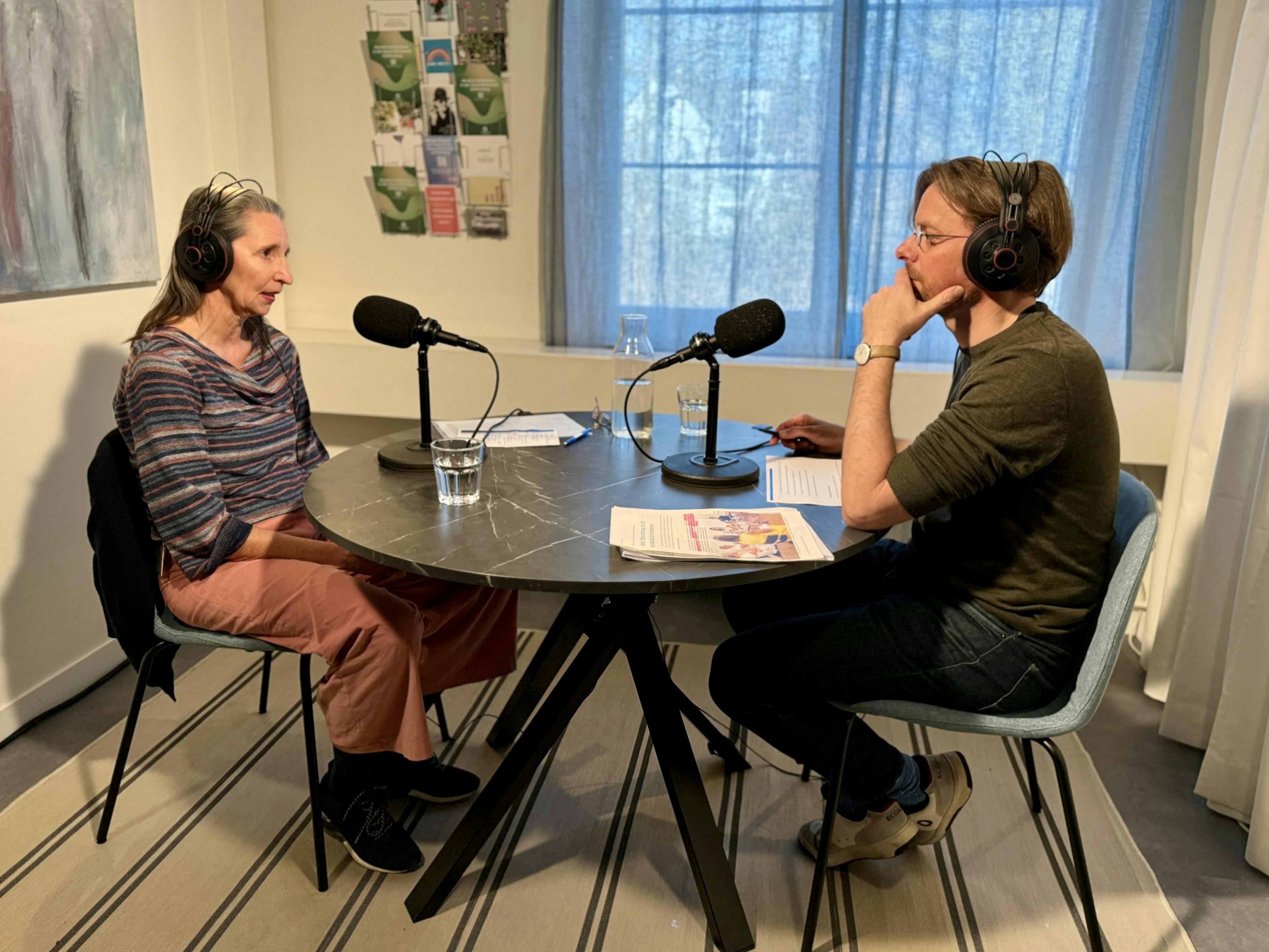 Zwei Personen bei einer Podcast-Aufnahme im Studio.